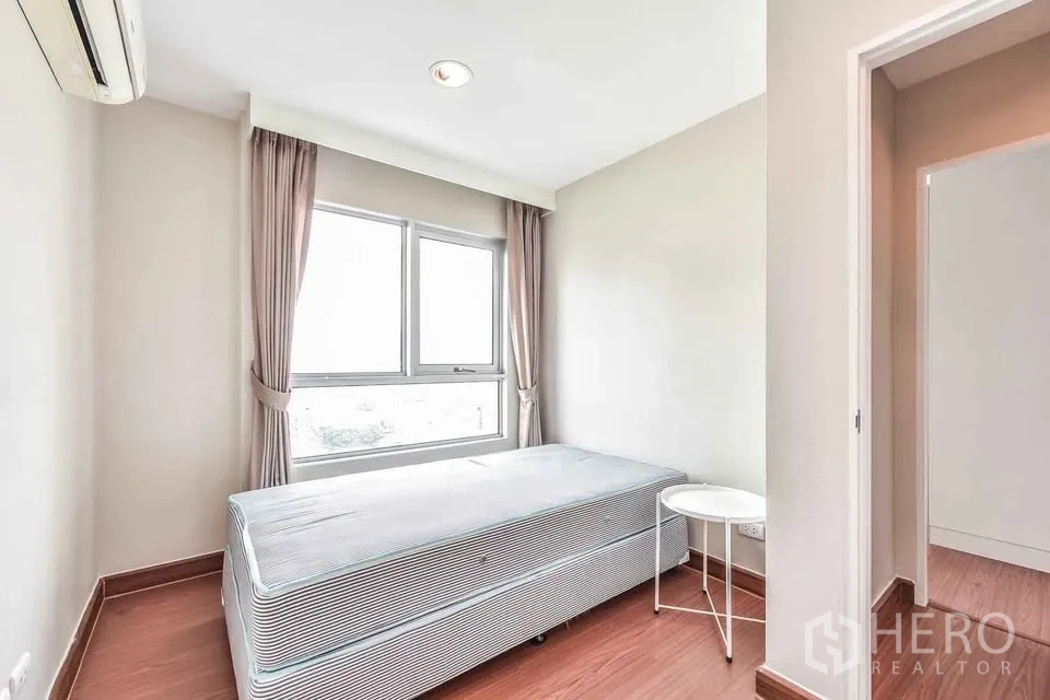 公寓 for rent in Huai Khwang, Bangkok - 明亮卧室，配单人床、窗户、窗帘和床边小桌。