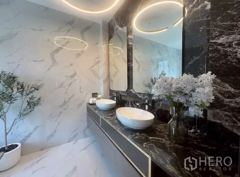 独立式住宅 出租在Lat Phrao, Bangkok - 豪华浴室，黑色大理石双台盆、双镜与环形灯光。
