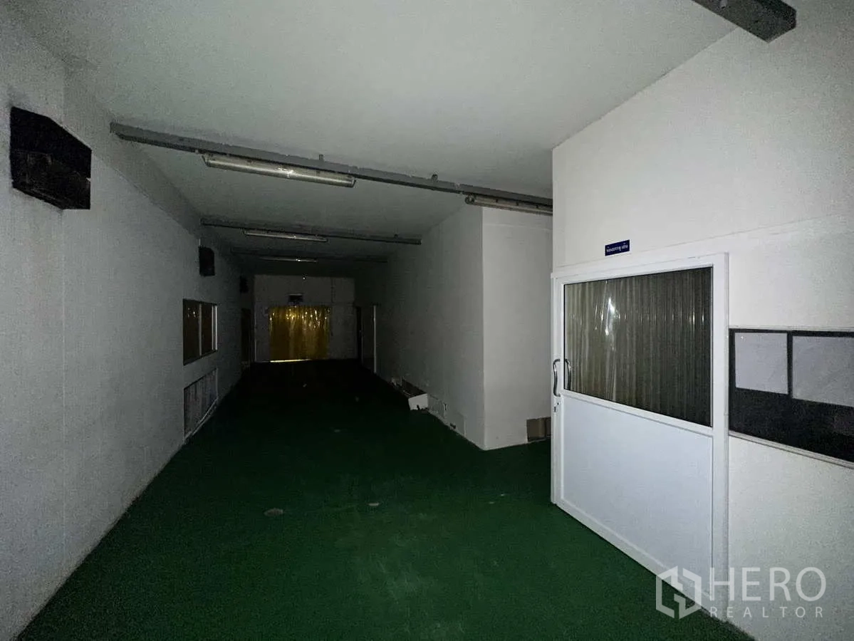 工厂 出租或出售在Bang Yai, Nonthaburi - 洁净走廊，绿色地坪通向PVC门帘后的处理间。