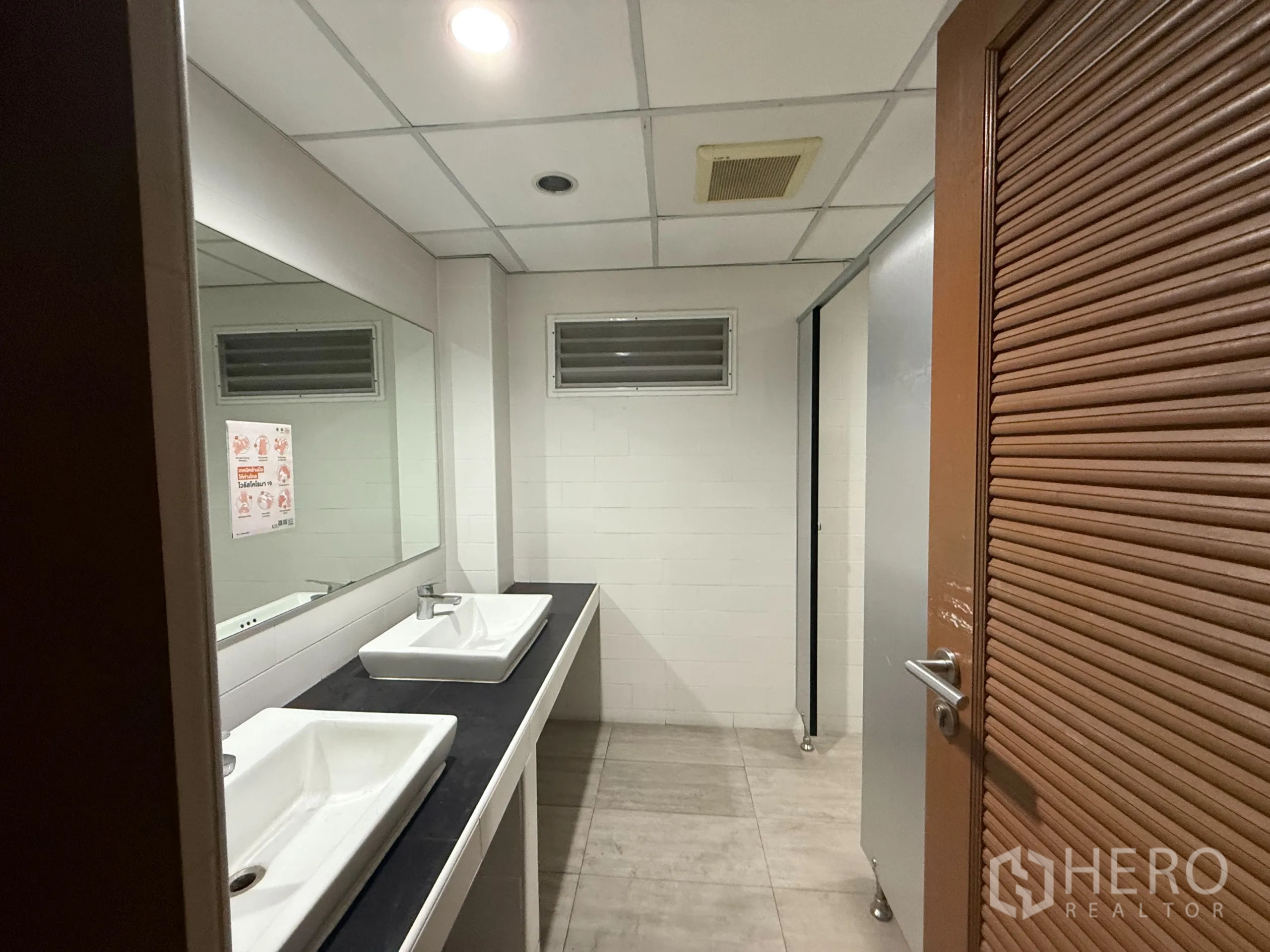 Office Space for rent in Bueng Kum, Bangkok - Restroom with double sinks, large mirror and tiled walls.