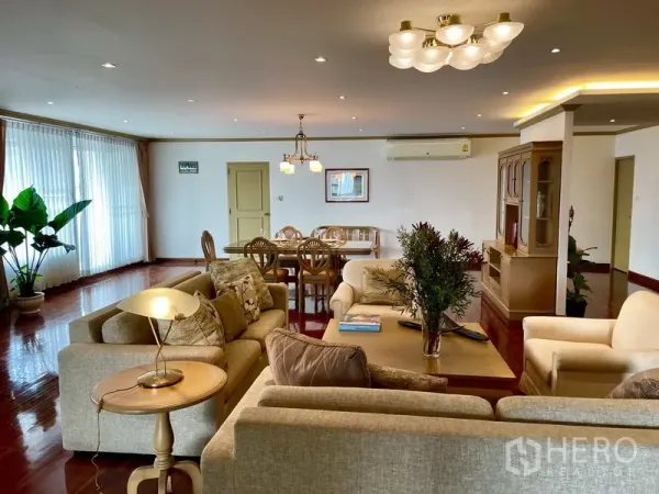 Condominium for rent or sale in Watthana, Bangkok - Spacious condo living and dining area with hardwood floors, neutral sofas, and full-height windows in Watthana, Bangkok.