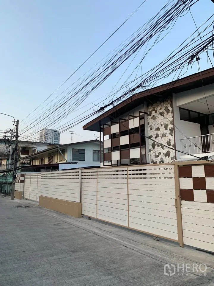 独栋房屋 for rent in Phra Khanong, Bangkok - 街景视角，可见高滑动大门与几何装饰外立面。