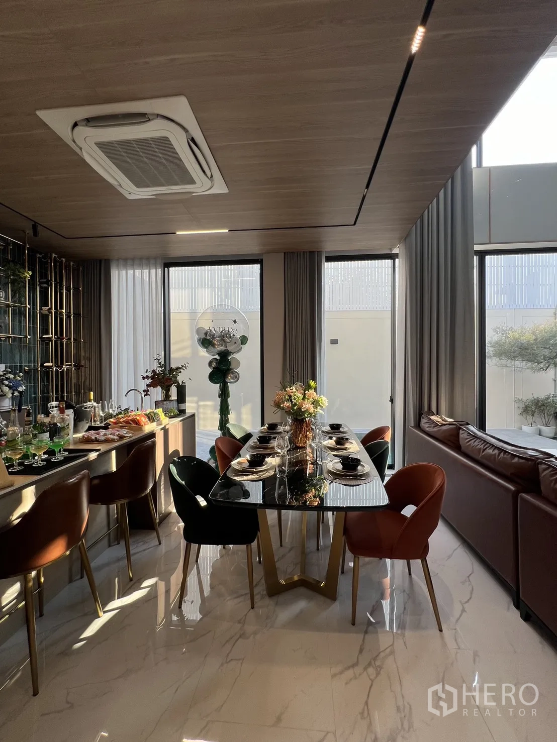 บ้าน ขายในLat Phrao, Bangkok - โต๊ะกินข้าวจัดเซ็ตข้างโซฟา รายล้อมด้วยผ้าม่านสูงจรดเพดาน