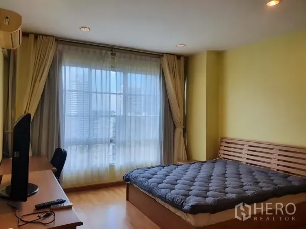 คอนโด ให้เช่าในKhlong Toei, Bangkok - ห้องนอนหลักกว้างพร้อมเตียง โต๊ะทำงาน และหน้าต่างบานใหญ่