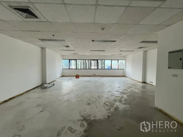 สำนักงาน ให้เช่าในWatthana, Bangkok - ออฟฟิศสภาพพร้อมตกแต่ง พื้นคอนกรีต ผนังสีขาว และหน้าต่างหลายบานมองเห็นสกายไลน์กรุงเทพฯ.