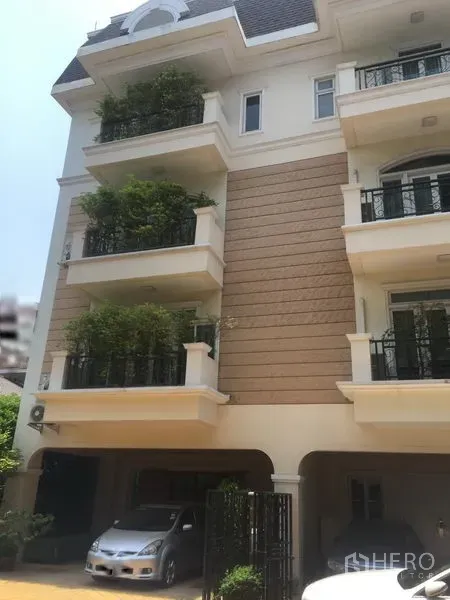 ทาวน์เฮาส์ ขายในHuai Khwang, Bangkok - ด้านหน้าทาวน์เฮ้าส์ 4 ชั้น มีระเบียงปลูกต้นไม้และที่จอดรถในร่ม ย่านห้วยขวาง