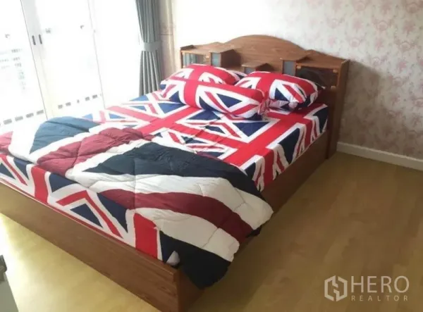 联排别墅 出租在Prawet, Bangkok - 采光充足的卧室，木床，花纹背景墙，推拉门通向阳台。