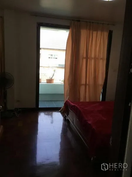 บ้าน ให้เช่าหรือขายในHuai Khwang, Bangkok - ห้องนอนเปิดสู่ระเบียงผ่านประตูกระจกบานเลื่อนพร้อมผ้าม่านสีพีช