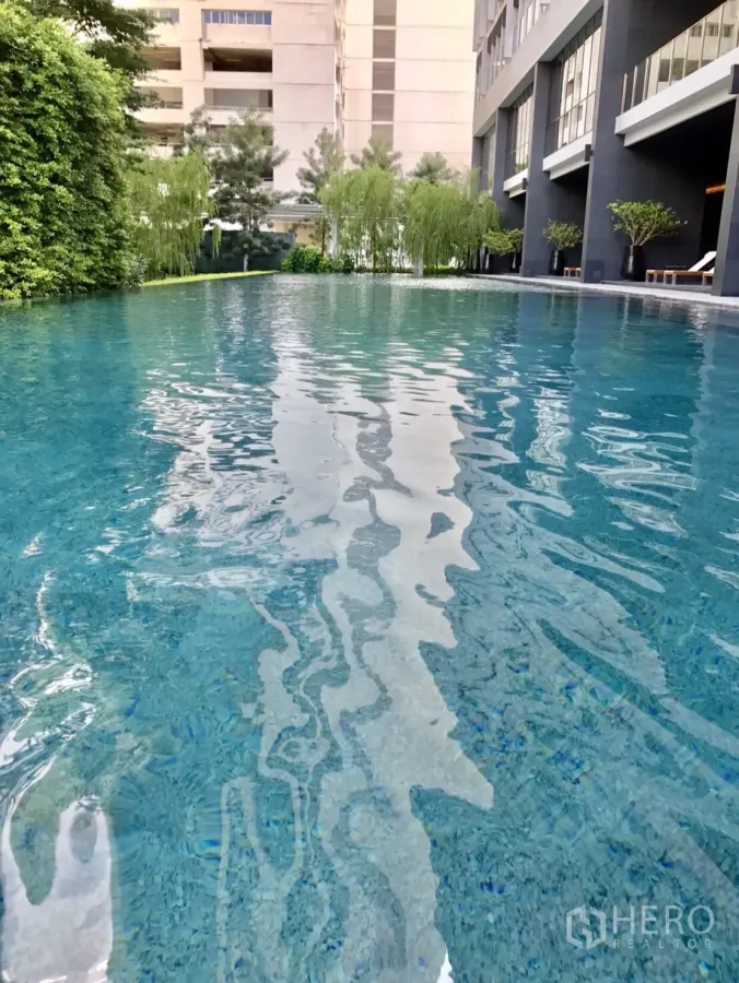 Condominium for rent in Pathum Wan, Bangkok - Resort-style outdoor swimming pool with lush greenery at a modern Bangkok condo.
