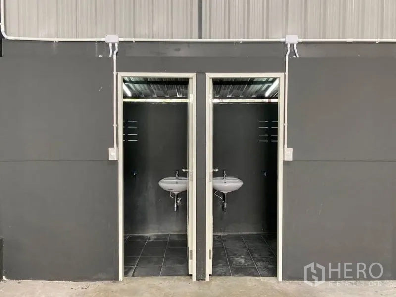 คลังสินค้า ให้เช่าในLat Phrao, Bangkok - ห้องน้ำคู่ภายในโกดัง มีอ่างล้างมือแบบแขวนผนัง.