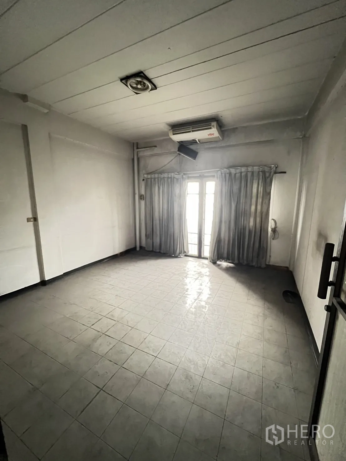 店屋 出租在Watthana, Bangkok - 楼上房间铺地砖，壁挂空调，落地阳台门与窗帘。