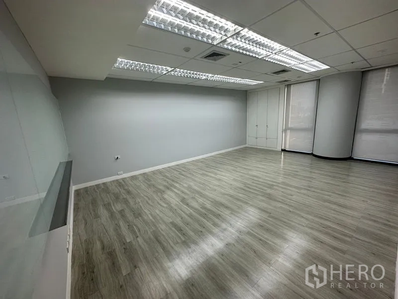 Office Space for rent - Bright office room with light grey floors, roller blinds, built-in closet and LED troffer lights.