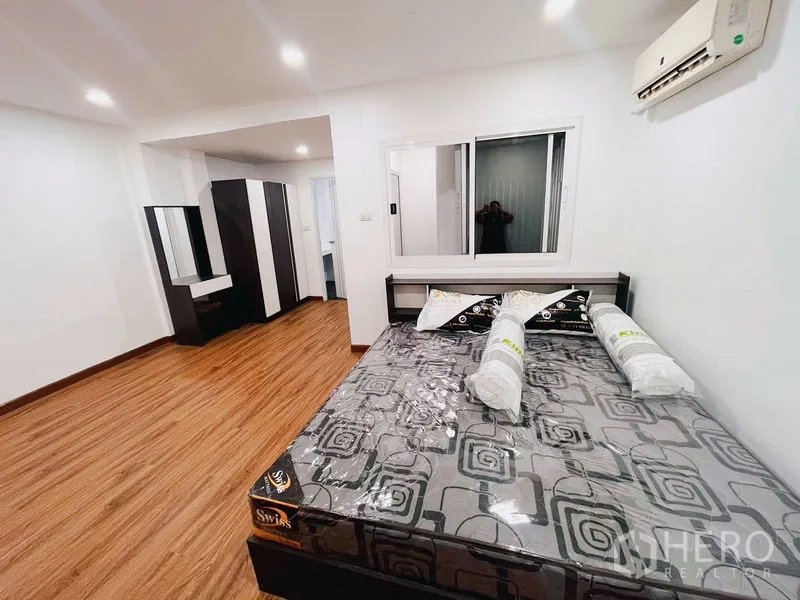 联排别墅 出租在Huai Khwang, Bangkok - 第二卧室，大床、衣柜、木地板与窗户采光。