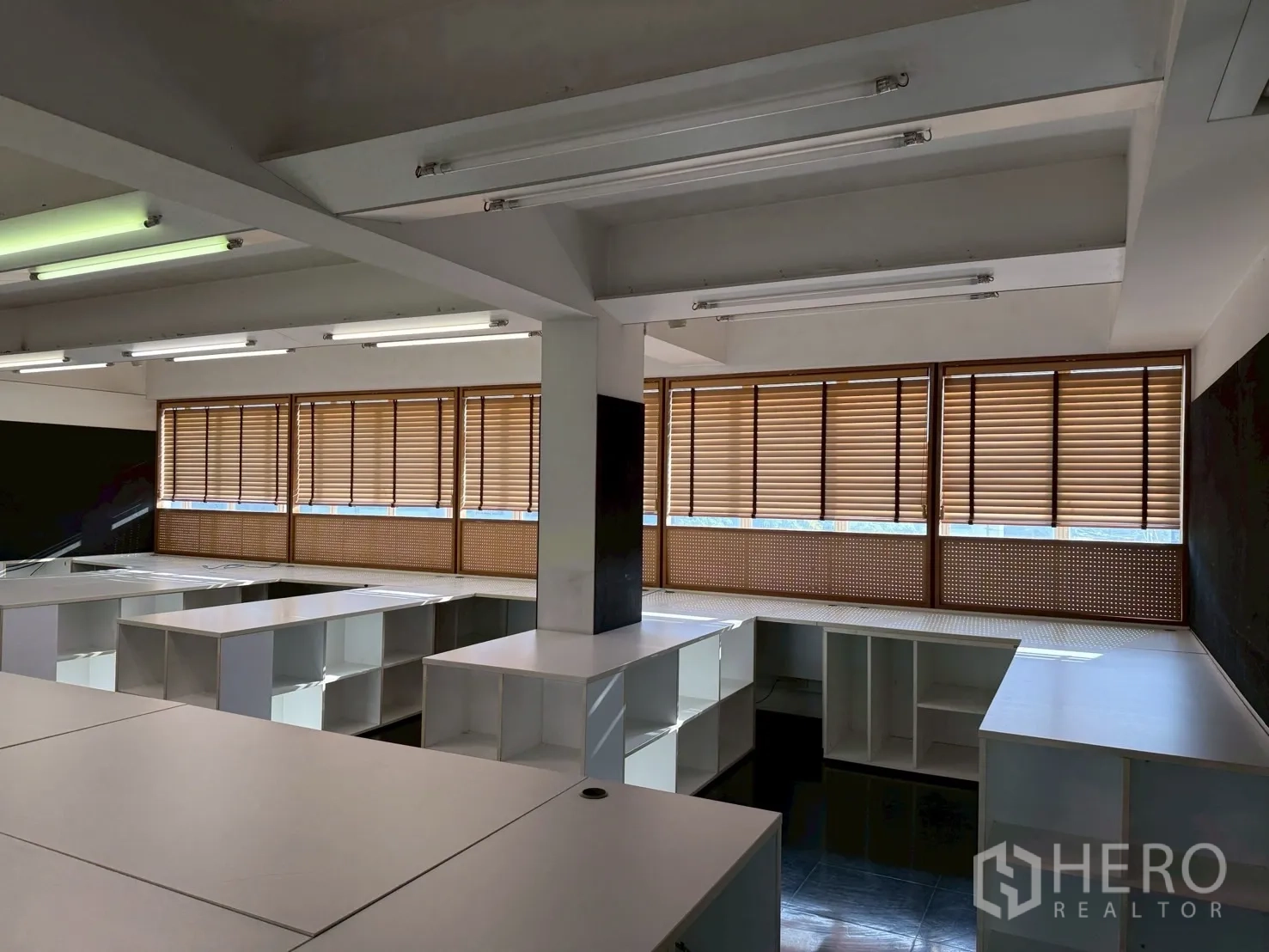 Office Space for rent in Huai Khwang, Bangkok - Spacious office floor with multiple work islands and wide windows fitted with wooden blinds.
