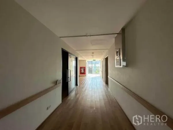 独立商业地产 出租在Bang Kapi, Bangkok - 宽阔走廊设安全扶手，尽头为明亮窗户与应急设备。