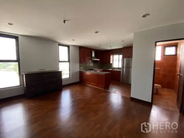 สำนักงานที่บ้าน ให้เช่าในPhra Khanong, Bangkok - ห้องนั่งเล่นเชื่อมครัวพื้นไม้ พร้อมตู้บิลท์อิน ตู้เย็นสแตนเลส และห้องน้ำกระเบื้องใกล้เคียง