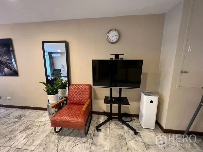 ทาวน์เฮาส์ ให้เช่าหรือขายในSuan Luang, Bangkok - มุมตกแต่งมีเก้าอี้หนังลายควิลท์ กระจกยาว ทีวียืน และเครื่องฟอกอากาศ