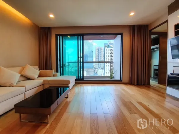 公寓 出租在Bang Rak, Bangkok - 客厅通向玻璃栏杆阳台，俯瞰曼谷天际线