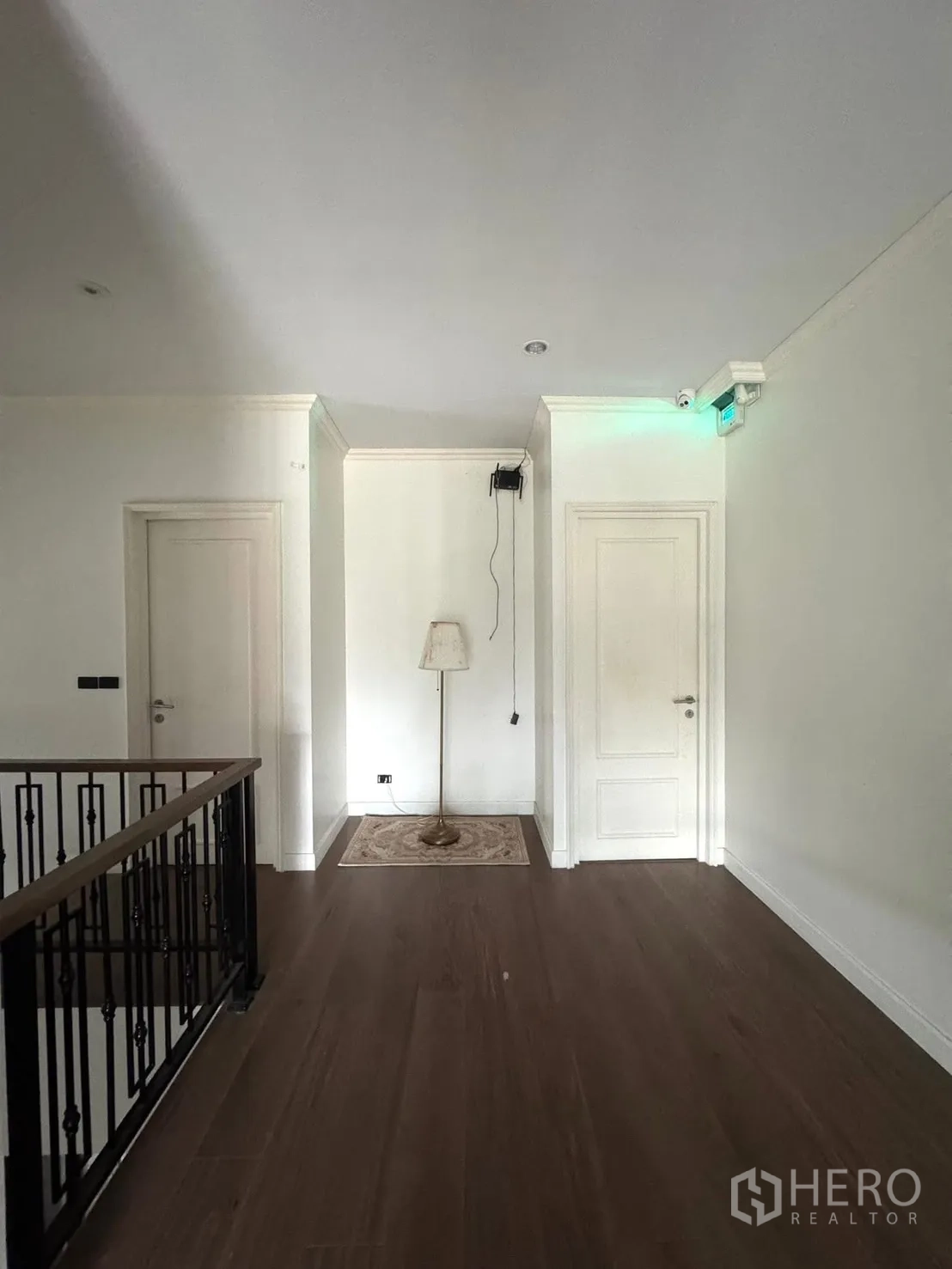 独立式住宅 出售在Mueang Pathum Thani, Pathum Thani - 二楼走廊，木地板、白色门与铁艺栏杆。