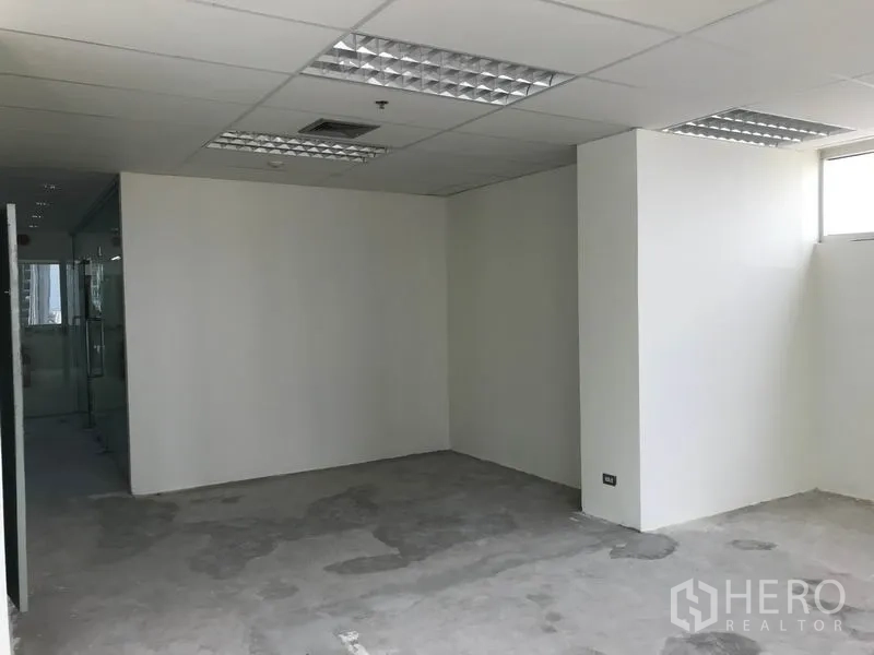 Office Space for rent in Khlong Toei, Bangkok - Compact enclosed workspace with white walls under grid ceiling lights.