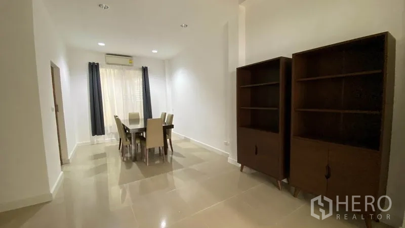 Townhouse for rent in Wang Thonglang, Bangkok - Bright dining area with tiled floors, curtains, and dark wood shelving in a Bangkok townhouse.