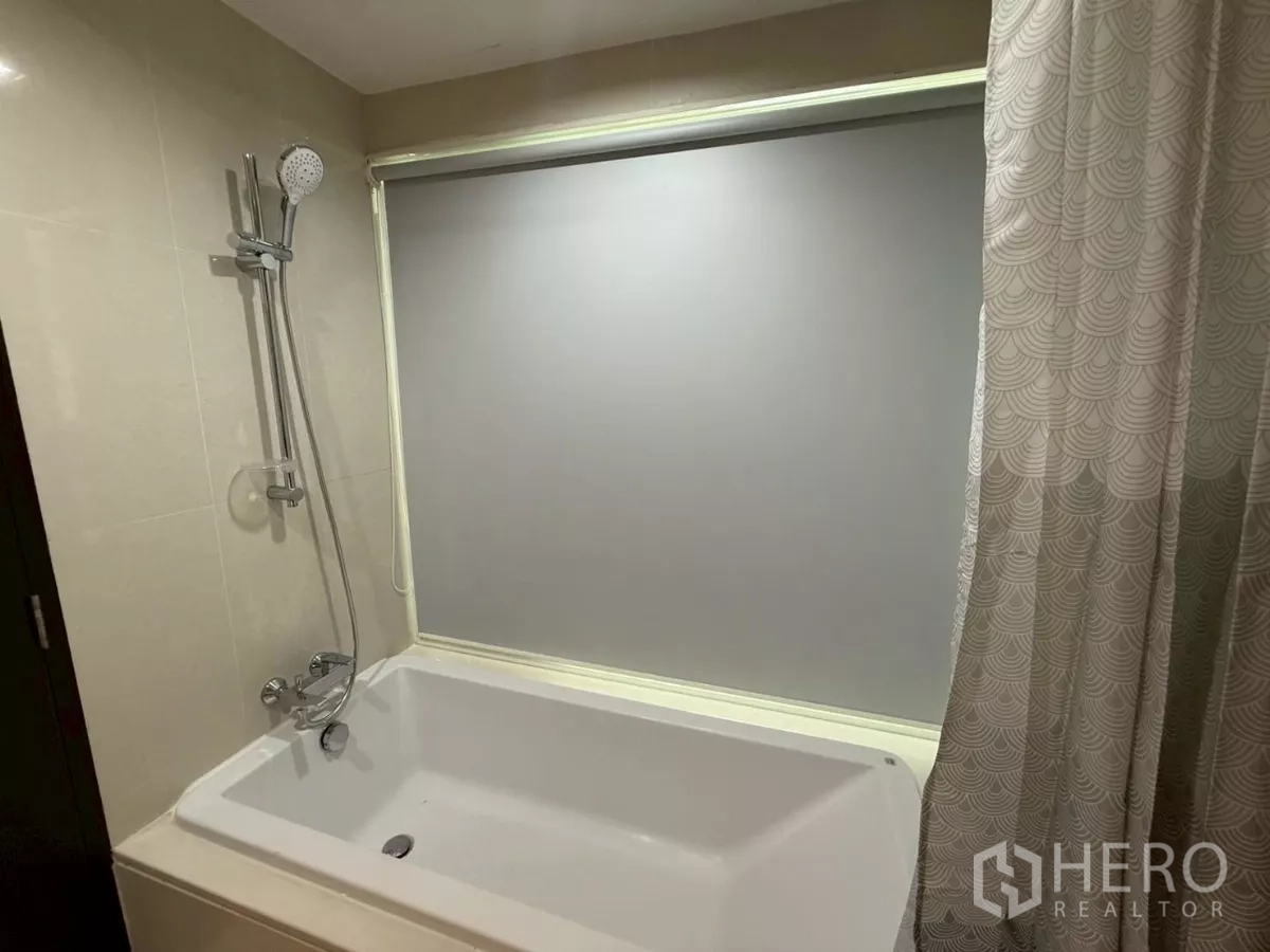 คอนโด ให้เช่าในWatthana, Bangkok - อ่างอาบน้ำพร้อมฝักบัวมือถือและมู่ลี่กันมองในห้องน้ำปูกระเบื้อง