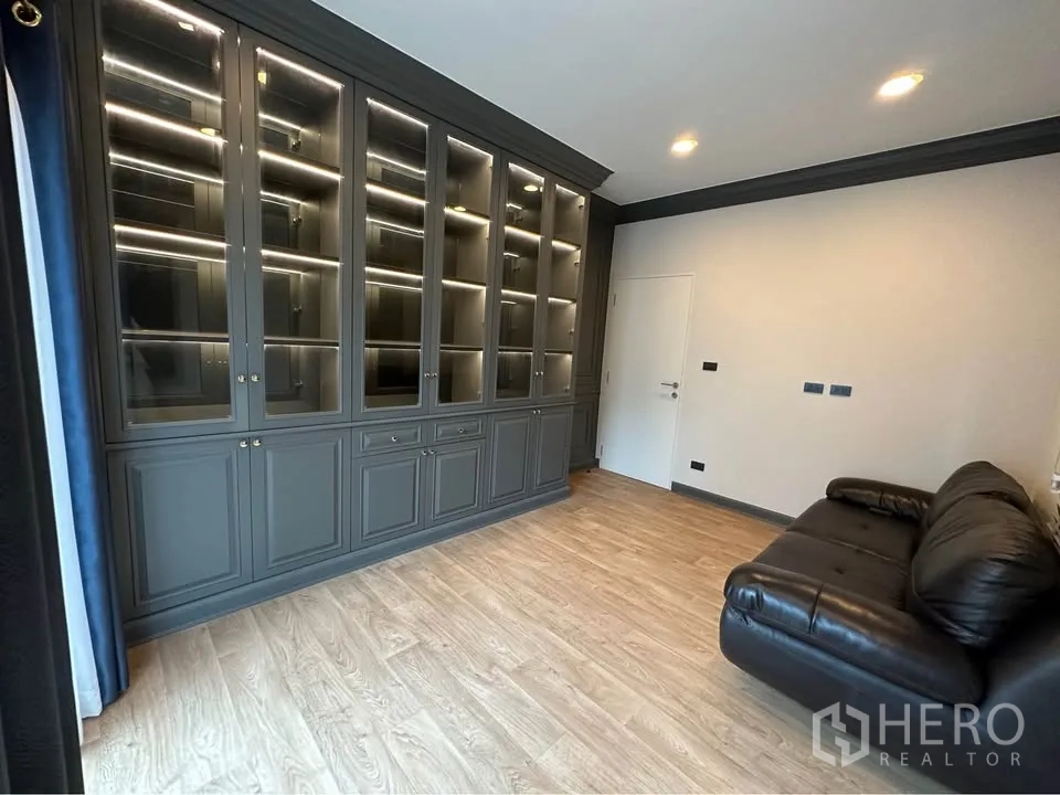 บ้านเดี่ยว for rent in Bang Kapi, Bangkok - ห้องนั่งเล่น/ทำงานมีตู้บิลต์อินสูงจรดเพดานพร้อมไฟ และโซฟาหนัง