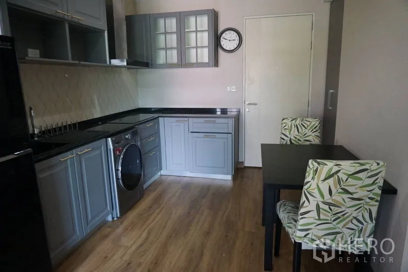 คอนโด ขายในKhlong Toei, Bangkok - ครัวเปิดตู้สีเทา เคาน์เตอร์หินสีดำ เครื่องซักผ้าอบและโต๊ะทานอาหารสองที่นั่ง