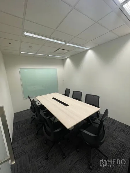 Office Space for rent in Dusit, Bangkok - Enclosed meeting room for eight with long table, mesh chairs and whiteboard.