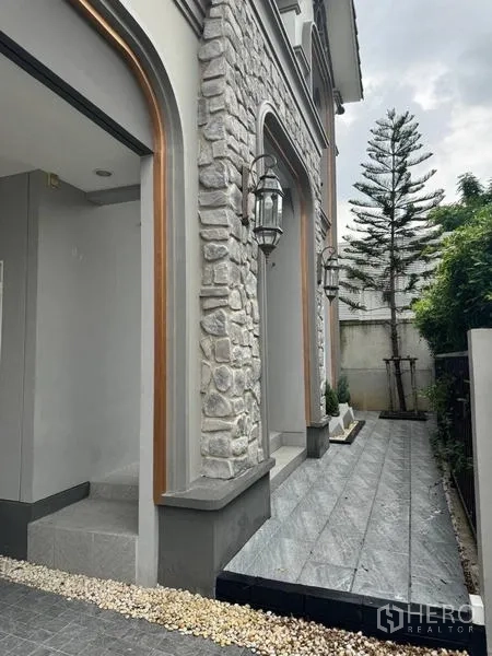 Detached House for rent - Side exterior pathway with stone-clad arches and lantern lights