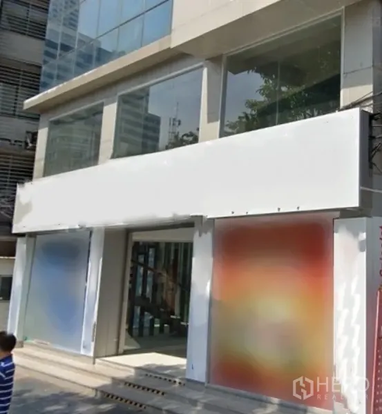 零售空间 出租在Bang Rak, Bangkok - 现代商业建筑，街道层大面积玻璃立面与空白招牌。