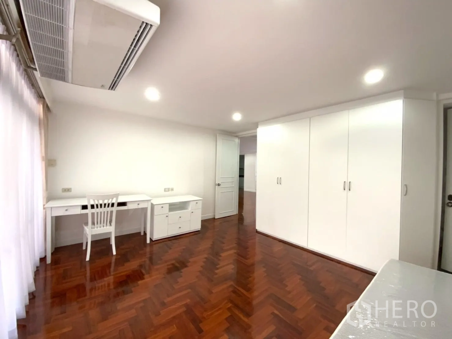 คอนโด ให้เช่าในWatthana, Bangkok - มุมห้องนอนพร้อมตู้เสื้อผ้าใบใหญ่ โต๊ะทำงานยาวใต้หน้าต่าง และเครื่องปรับอากาศ