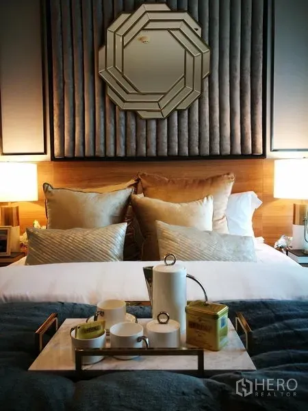 公寓 出租在Sathon, Bangkok - 舒适卧室，软包床头、装饰镜与整齐摆放的靠枕。