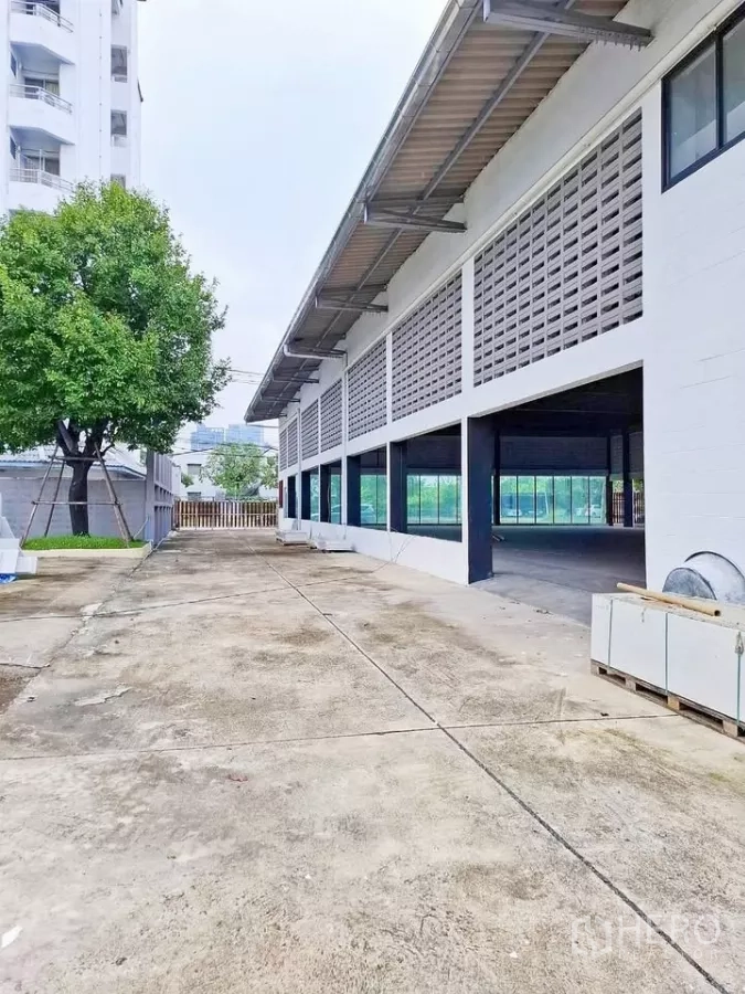 คลังสินค้า ให้เช่าในBang Kapi, Bangkok - ทางสัญจรยาวข้างอาคาร ใต้กันสาด มีช่องหน้าต่างและประตูรั้วสำหรับรถบรรทุก