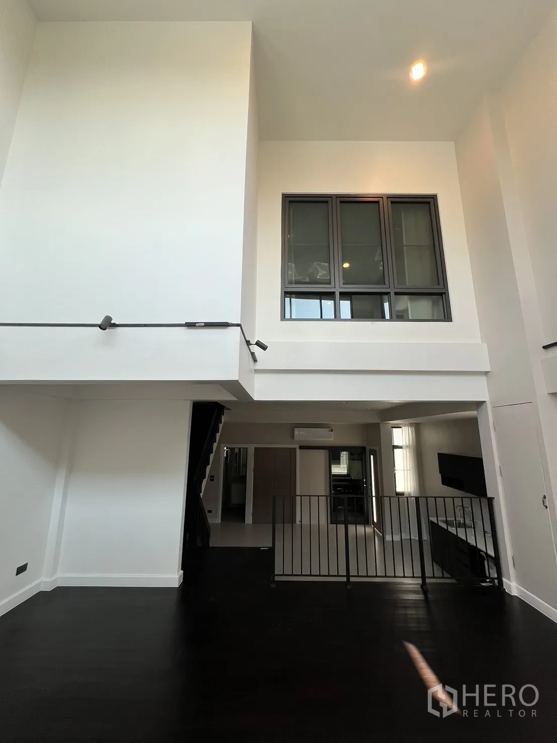 บ้าน ให้เช่าในSaphan Sung, Bangkok - เลานจ์เพดานสูงสองชั้น พื้นไม้สีเข้มและช่องหน้าต่างภายใน