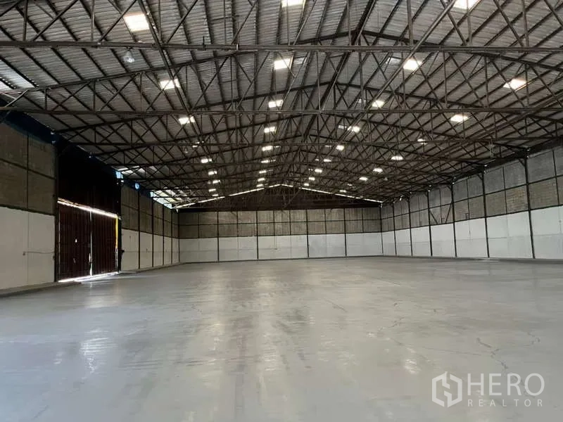 工厂 出租在Bang Pakong, Chachoengsao - 宽敞厂房内部，高钢结构屋架，抛光混凝土地面与明亮顶灯。