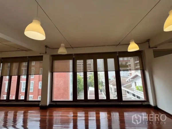 Office Space for rent in Watthana, Bangkok - Tall windows facing a red-brick building, bringing ample daylight into the office.