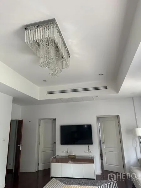 Detached House for sale in Saphan Sung, Bangkok - Ceiling detail with rectangular crystal chandelier above a TV wall and doors.