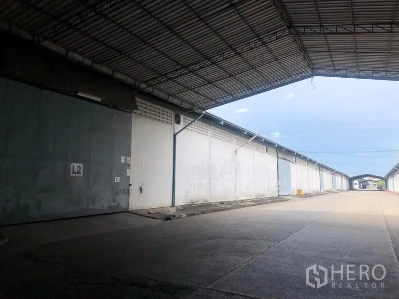 货栈 出租在Bang Pa-in, Phra Nakhon Si Ayutthaya - 大型金属雨棚下的装卸通道，沿线有多处仓库入口。