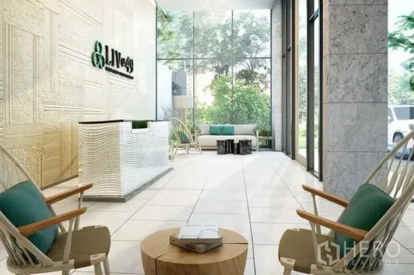 คอนโด ขายในWatthana, Bangkok - ล็อบบี้คอนโดสว่างโปร่ง เคาน์เตอร์ต้อนรับและผนังกระจกสูงมองเห็นต้นไม้ด้านนอก.