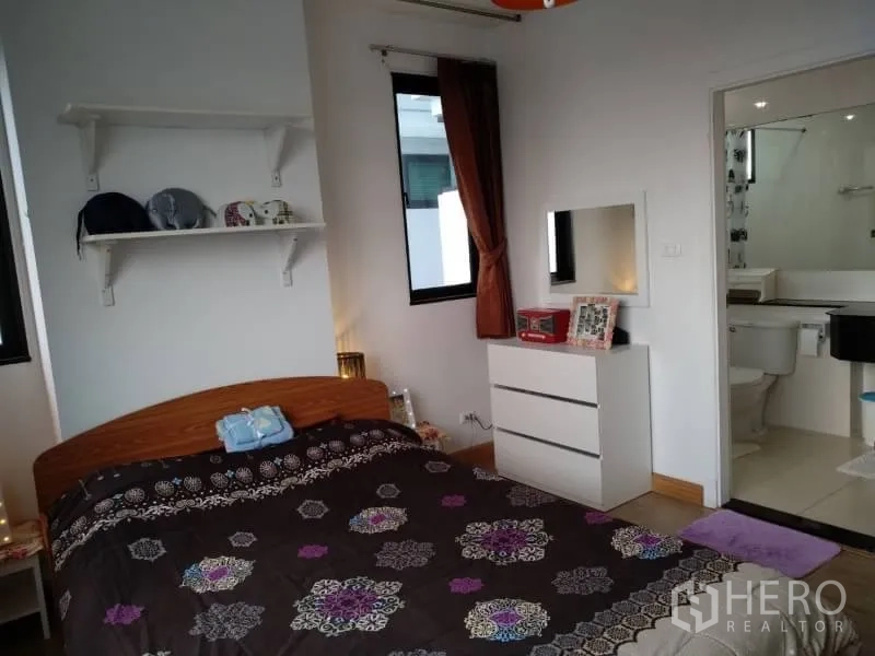 Condominium for rent in Watthana, Bangkok - Master bedroom with dresser, wall shelves and entrance to an en-suite bathroom.