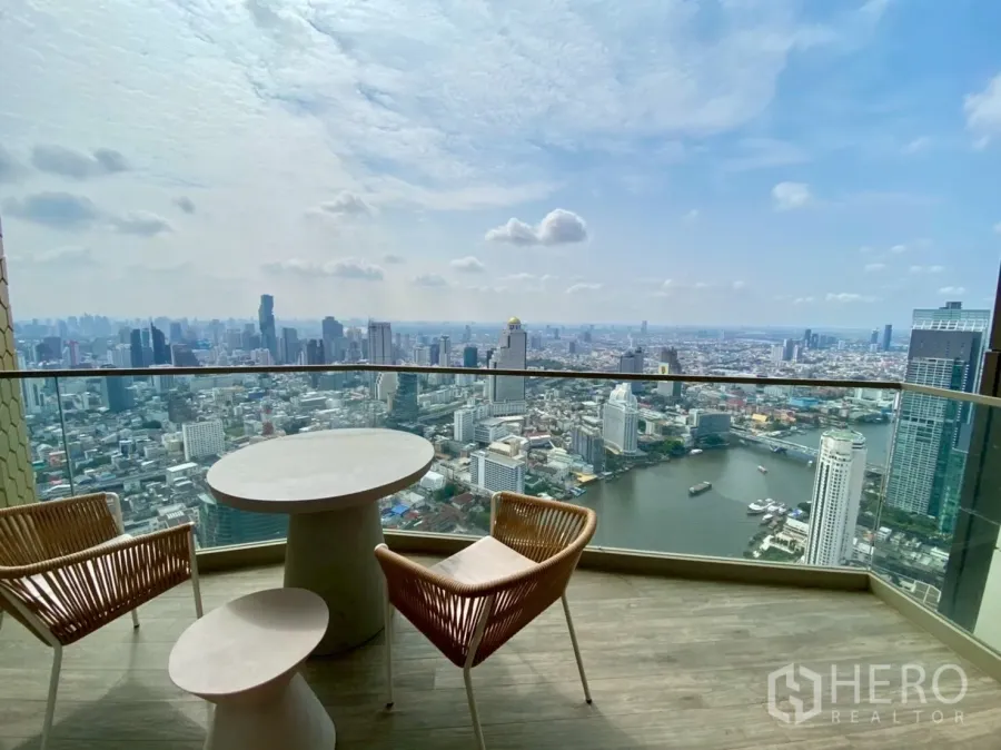 คอนโด ให้เช่าในKhlong San, Bangkok - ระเบียงส่วนตัวพร้อมโต๊ะกลมและเก้าอี้ มองเห็นแม่น้ำเจ้าพระยาและสกายไลน์กรุงเทพฯ