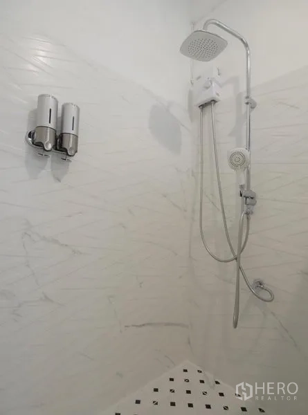 Townhouse for rent in Khlong Toei, Bangkok - Close-up of the walk-in shower with square rain head, handheld sprayer and mounted soap dispensers on white walls.