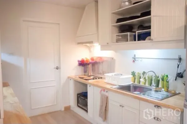 คอนโด ให้เช่าหรือขายในWatthana, Bangkok - ครัวโทนอ่อน เคาน์เตอร์ไม้ ชั้นเก็บของแบบเปิด และเตาไฟฟ้า