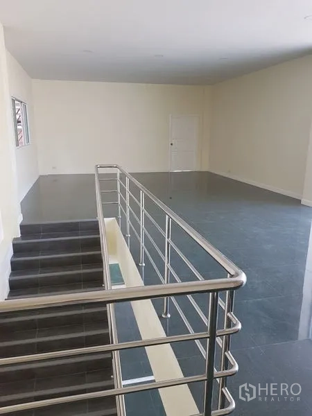 Factory for rent or sale in Mueang Samut Prakan, Samut Prakan - Second-floor office area with stainless handrail and dark tile flooring.
