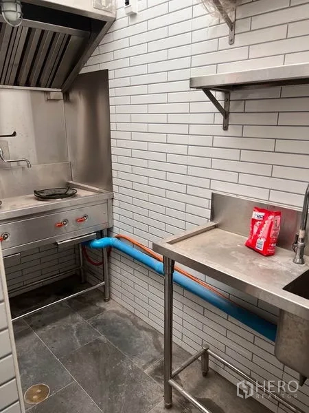 อาคารพาณิชย์ ให้เช่าหรือขายในWatthana, Bangkok - ครัวเตรียมอาหารสแตนเลสขนาดกะทัดรัด พร้อมฮู้ดดูดควันและผนังอิฐซับเวย์สีขาว