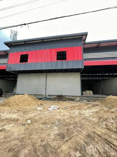 货栈 出租在Pathum Thani - 正立面带红灰色金属板与上层窗孔的前置体量。