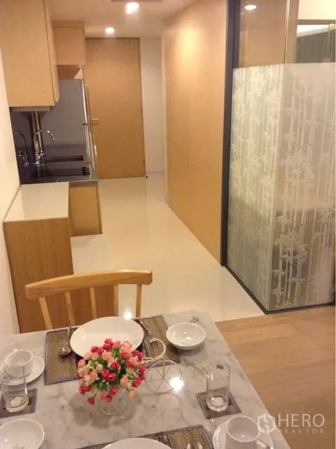 Condominium for rent or sale in Watthana, Bangkok - Open-plan kitchen and dining area with glass partition and warm lighting