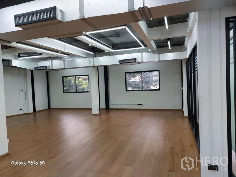 สำนักงาน ให้เช่าในKhlong Toei, Bangkok - มุมทำงานพร้อมหน้าต่างบานใหญ่ ผนังกระจกฝ้า และพื้นไม้.