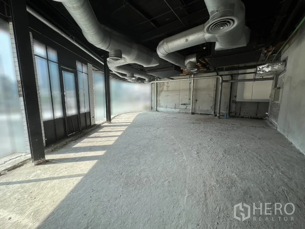 零售空间 出租在Pathum Wan, Bangkok - 毛坯室内带落地窗与外露空调风管，采光充足。